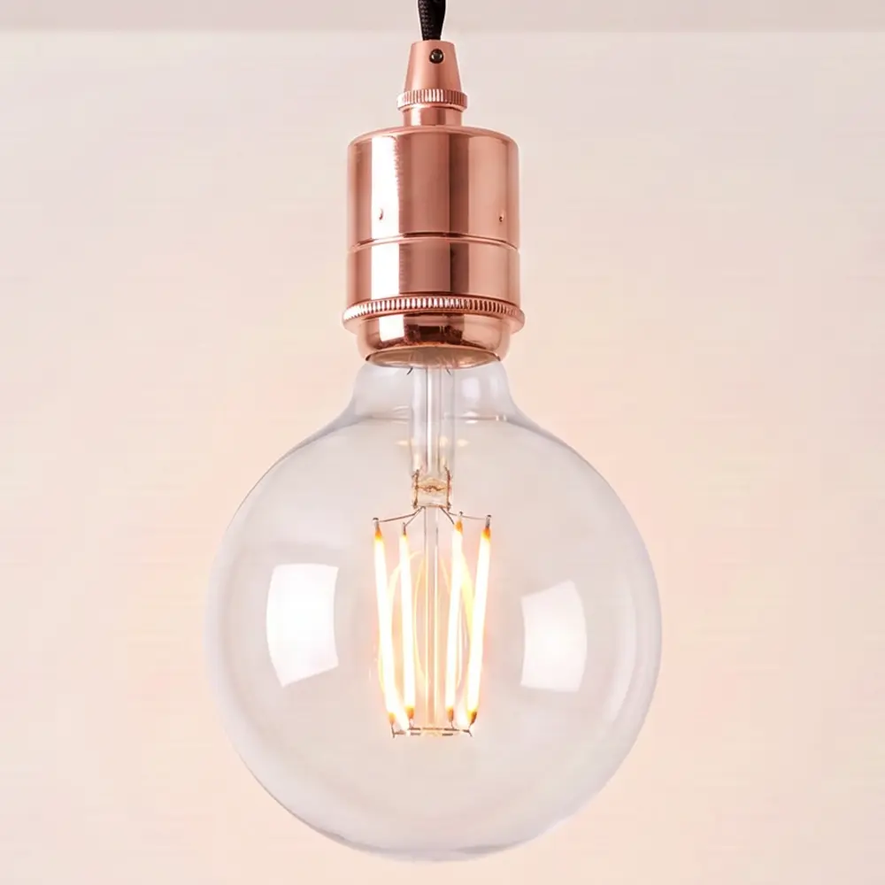 Close detail of the knurled copper bulb holder and clear globe filament bulb