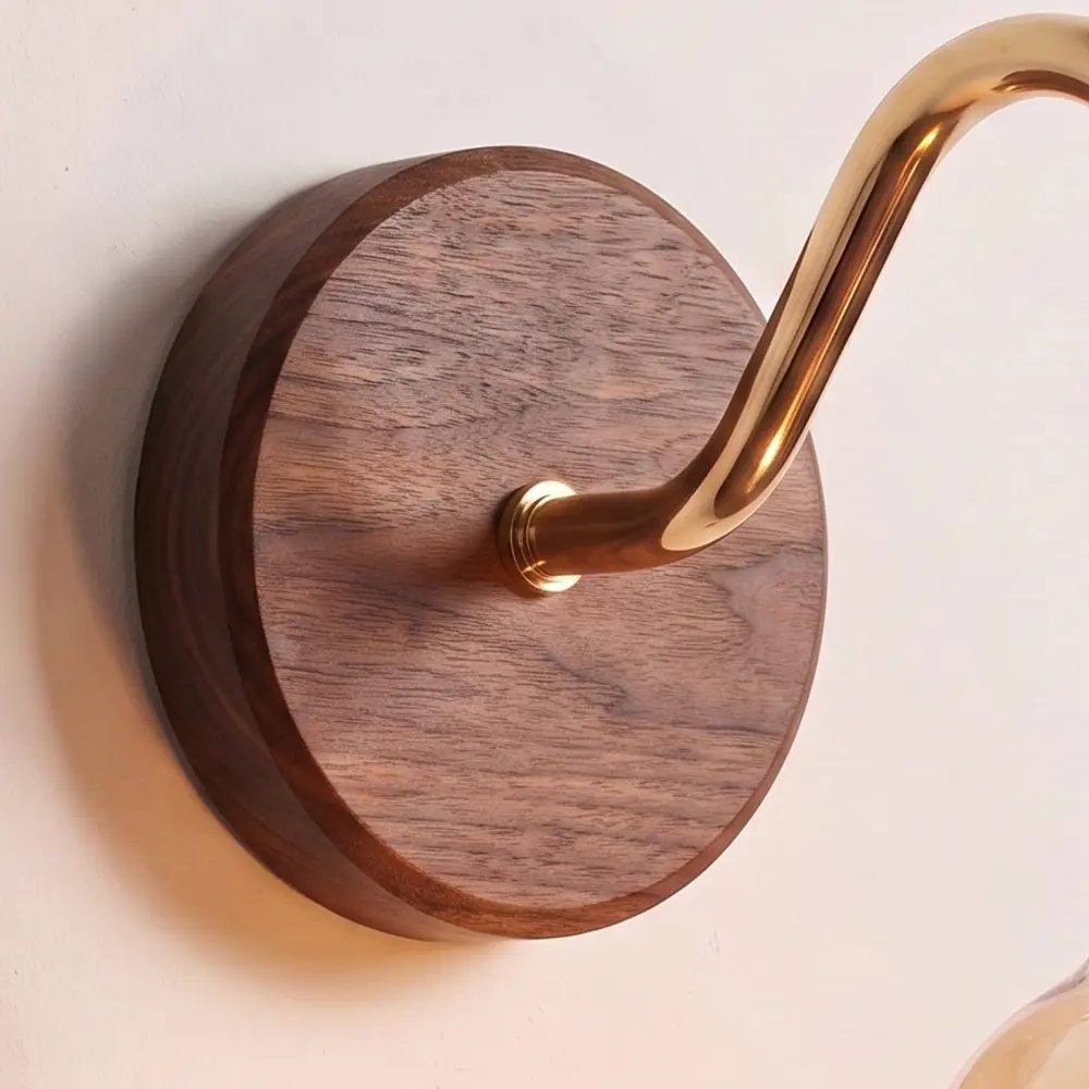 Close detail of the turned walnut back plate and the brass collar where the swan neck arm meets it