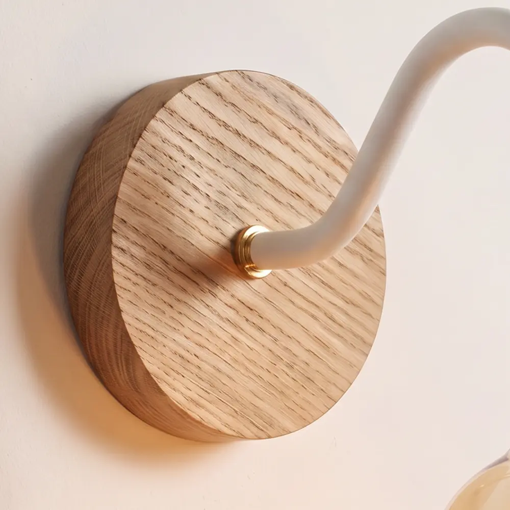 Close detail of the turned natural oak back plate and the white collar where the swan neck arm meets it